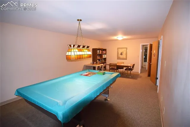 a room with pool table and chairs