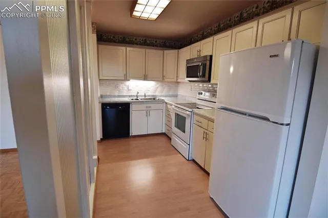 a kitchen with stainless steel appliances granite countertop a refrigerator a stove top oven a sink and dishwasher