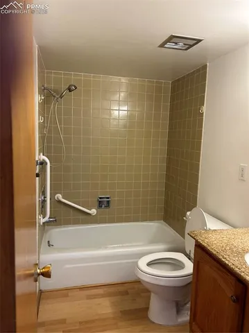 a bathroom with a granite countertop bathtub toilet and sink