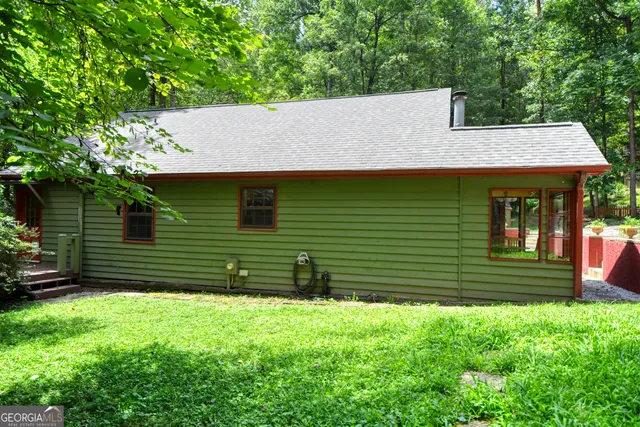 a view of a house with large windows and a small yard