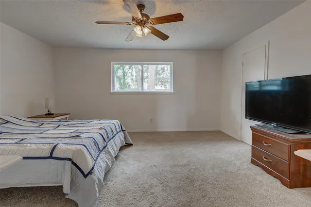 a spacious bedroom with a bed and a chandelier