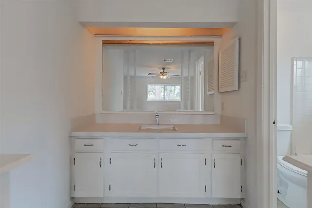 a bathroom with a granite countertop sink a toilet and a bathtub