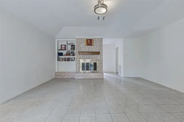 an empty room with fireplace and cabinet