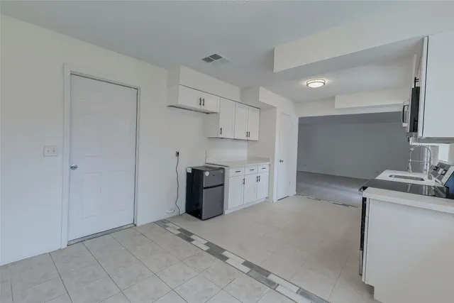 a view of kitchen with granite countertop a stove top oven microwave and cabinets