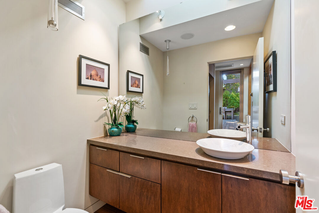 447 Sycamore Road Santa Monica, CA 90402 - Photo 11 of 36 a bathroom with a sink a mirror and a toilet