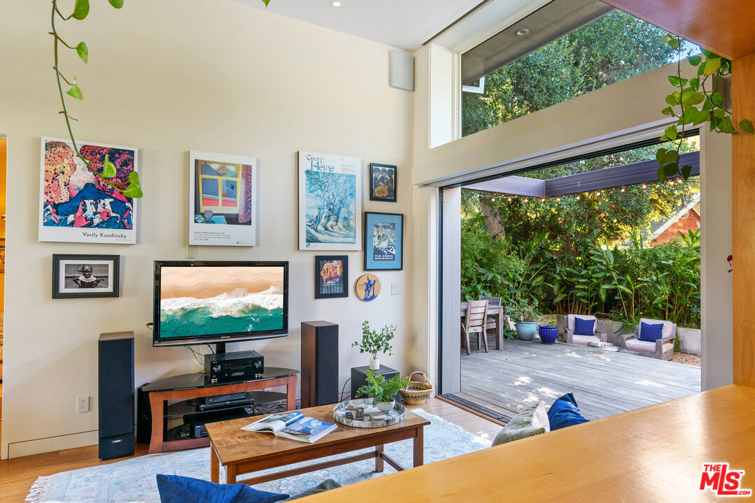 447 Sycamore Road Santa Monica, CA 90402 - Photo 21 of 36 a living room with furniture a flat screen tv and a floor to ceiling window