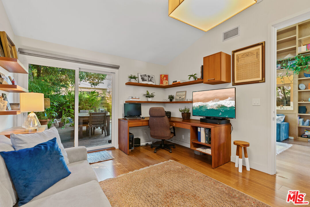 447 Sycamore Road Santa Monica, CA 90402 - Photo 25 of 36 a living room with furniture a large window and a flat screen tv