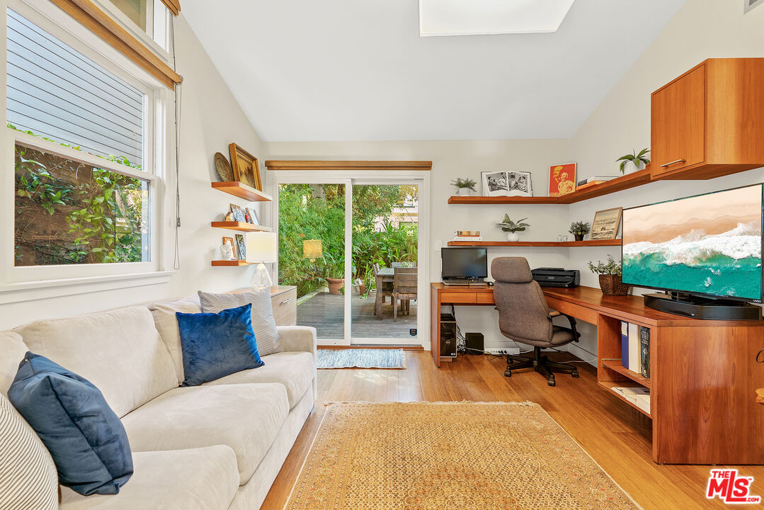 447 Sycamore Road Santa Monica, CA 90402 - Photo 26 of 36 a living room with furniture flat screen tv and a large window