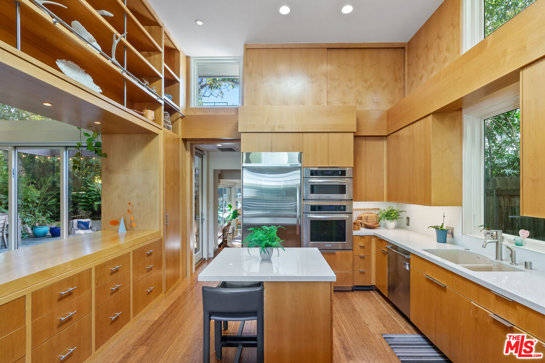 447 Sycamore Road Santa Monica, CA 90402 - Photo 9 of 36 a kitchen with stainless steel appliances kitchen island granite countertop a sink and cabinets