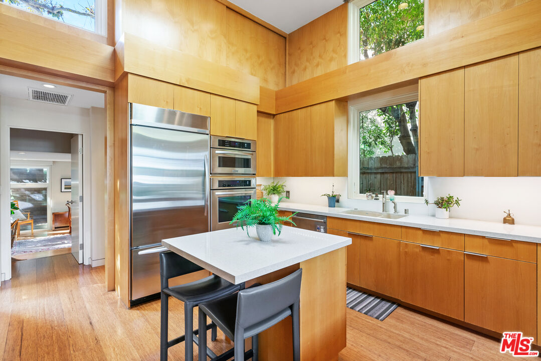 447 Sycamore Road Santa Monica, CA 90402 - Photo 10 of 36 a kitchen with a table chairs sink and wooden floor