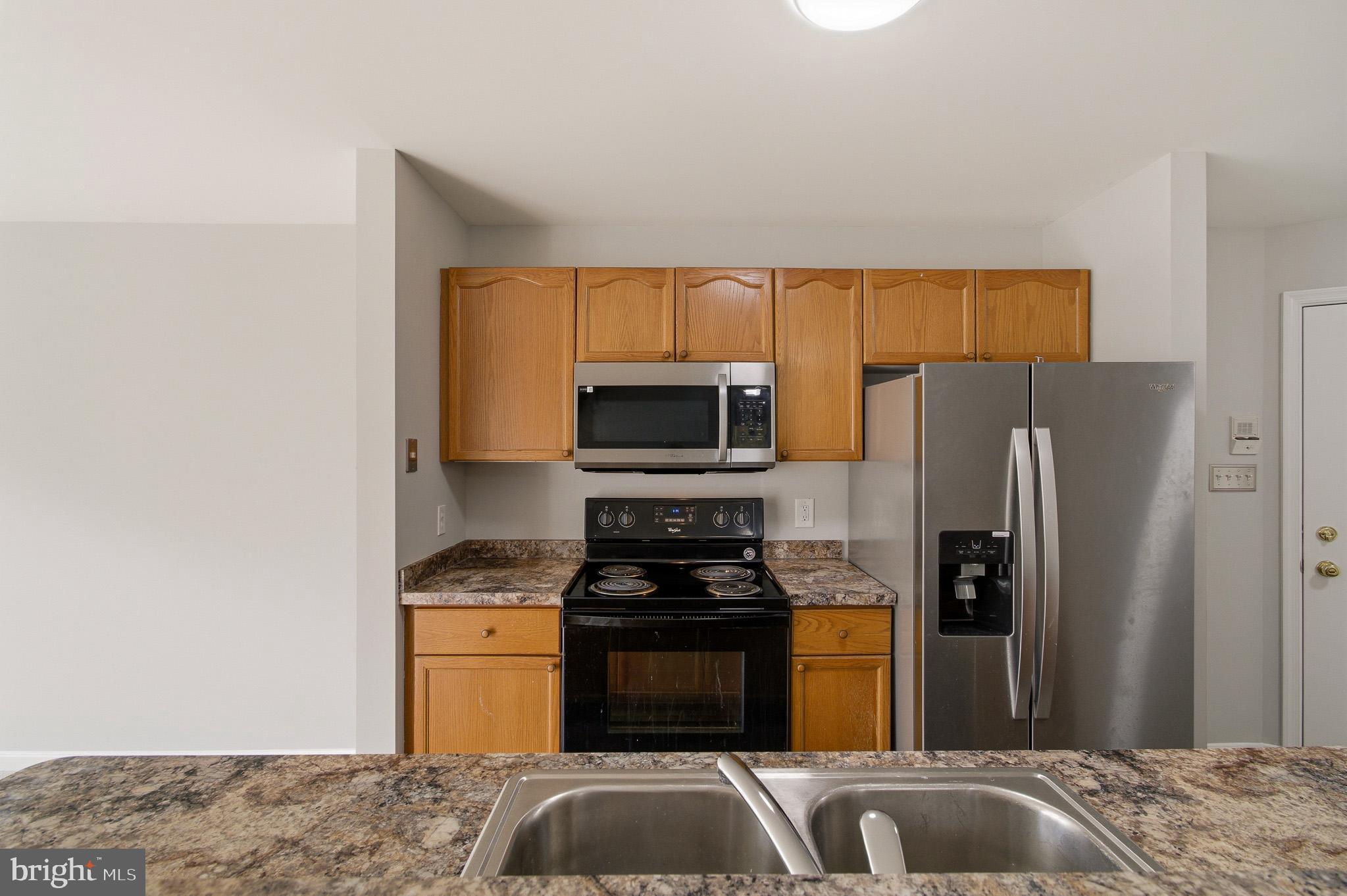 2400 Ellsworth Way, Unit 2D Frederick, MD 21702 - Photo 22 of 34 a kitchen with a refrigerator and a stove top oven