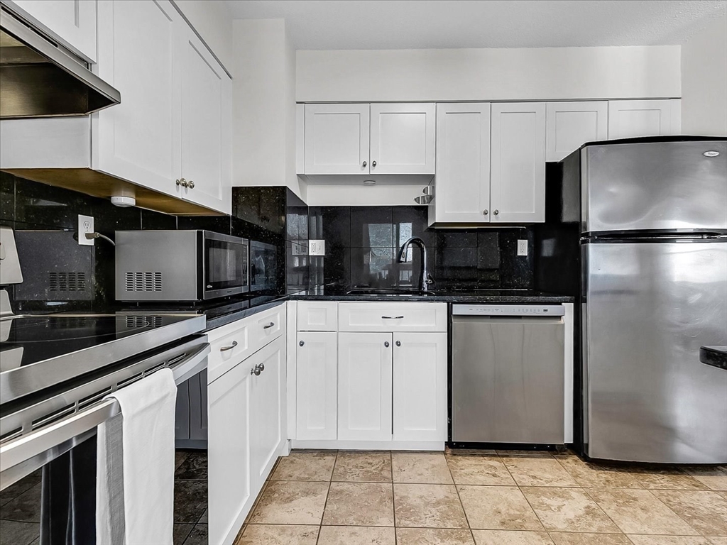 115 Water Street, Unit 14 Beverly, MA 01915 - Photo 17 of 38 a kitchen with white cabinets and stainless steel appliances