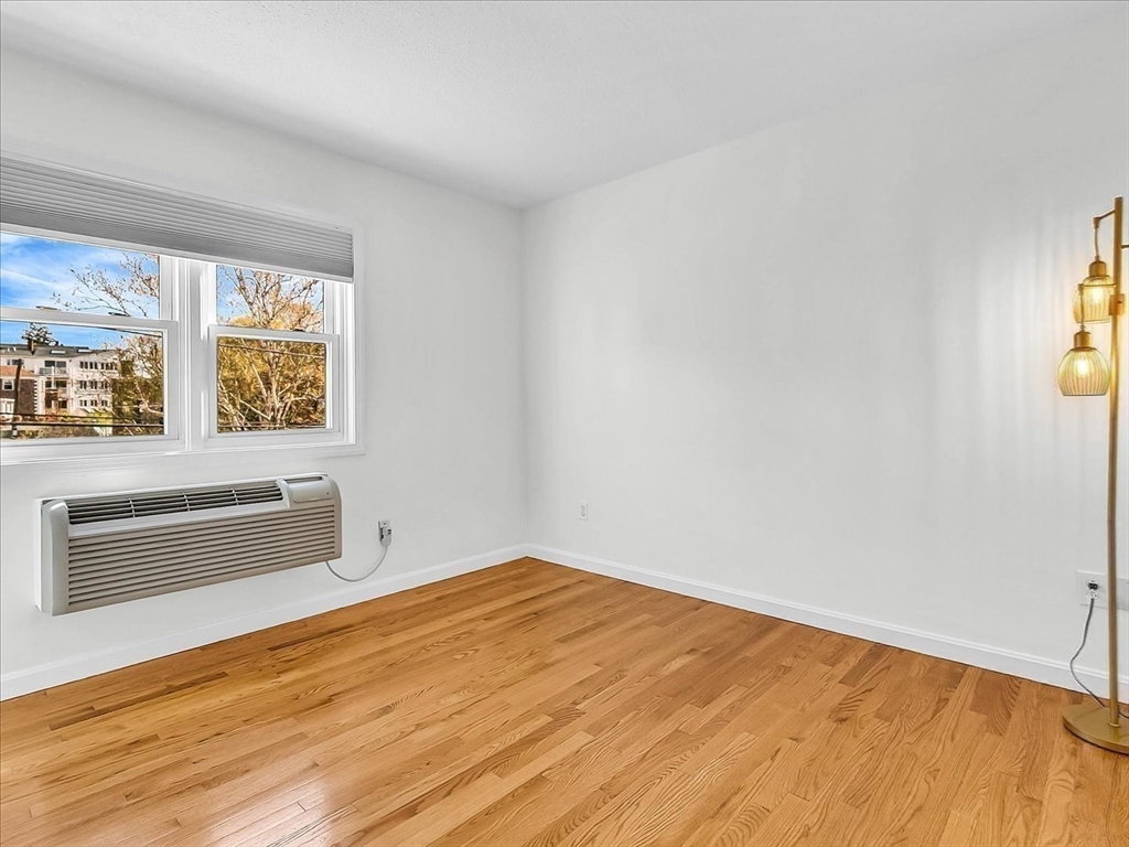 115 Water Street, Unit 14 Beverly, MA 01915 - Photo 19 of 38 a view of an empty room with a window and wooden floor