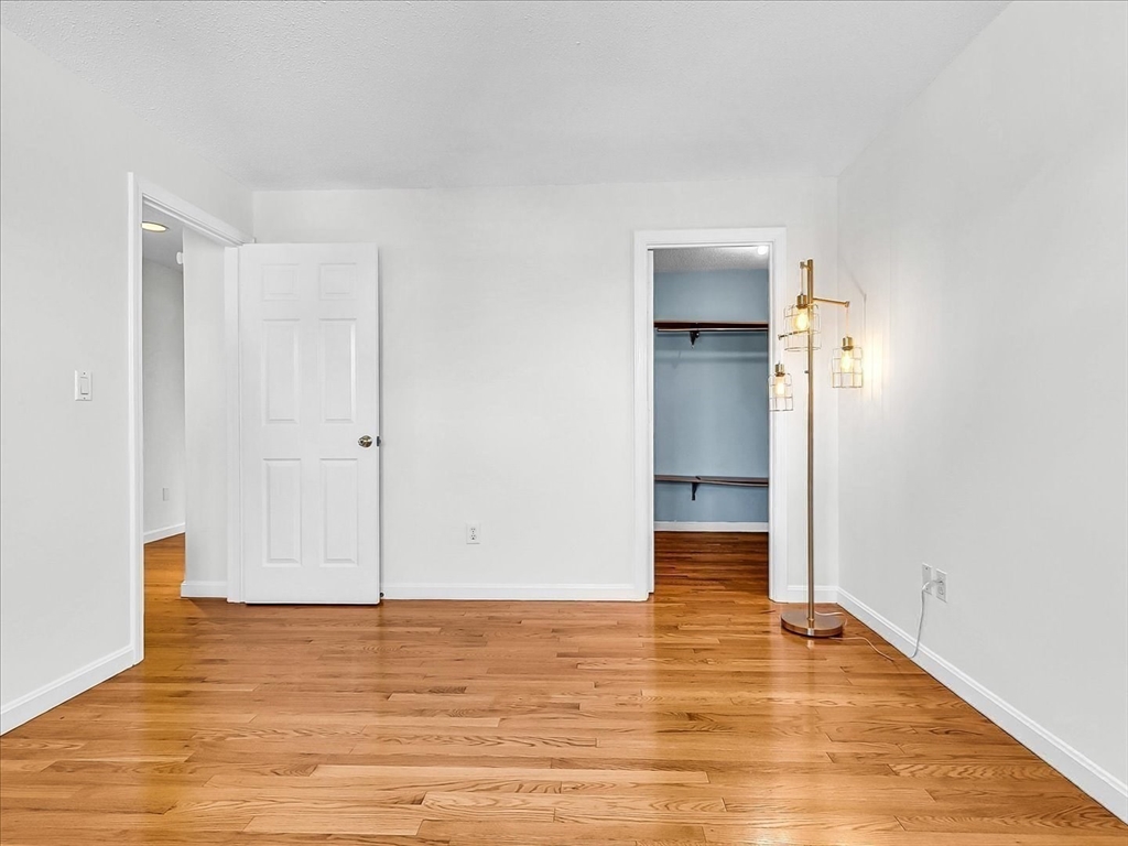 115 Water Street, Unit 14 Beverly, MA 01915 - Photo 27 of 38 a view of an empty room with wooden floor and closet