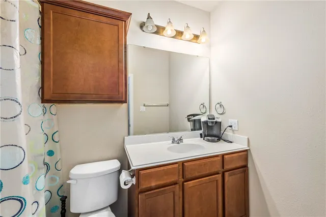 a bathroom with a sink a toilet and mirror