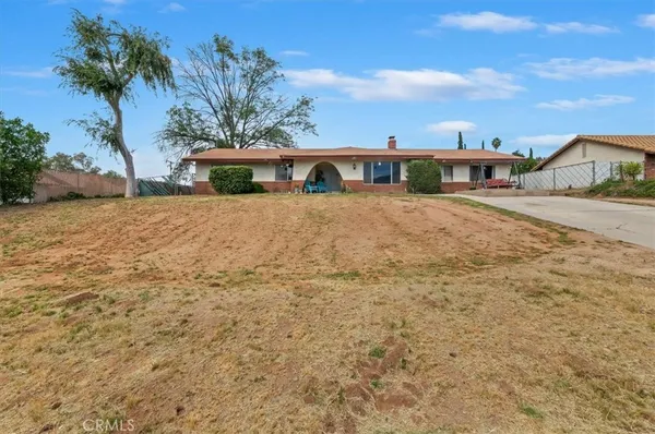 a front view of a house with a yard and ocean view