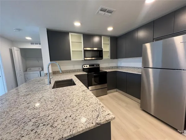 a kitchen with a sink and stainless steel appliances