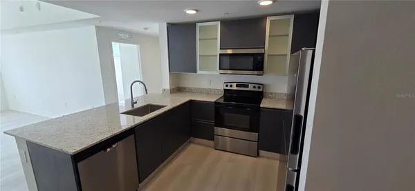a kitchen with granite countertop a sink and cabinets