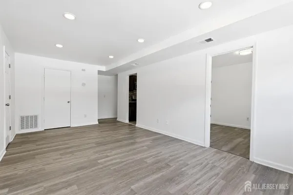 a view of an empty room with wooden floor