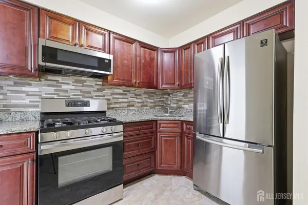 a kitchen with stainless steel appliances granite countertop a refrigerator stove a sink dishwasher and microwave
