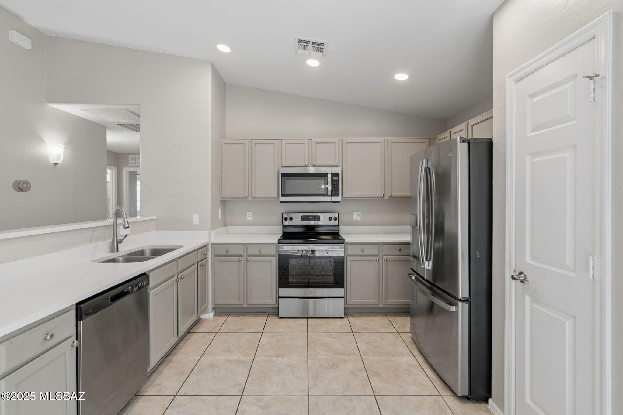 8244 South Lost Mountain Road Tucson, AZ 85747 - Photo 9 of 41 a kitchen with stainless steel appliances granite countertop a refrigerator and a sink