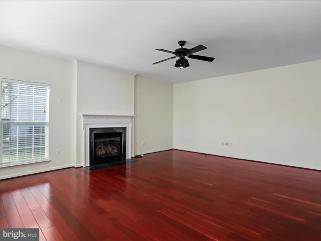 a bathroom with a toilet a sink a mirror a window and vanity