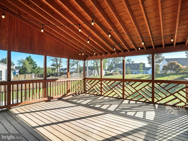 a view of a roof deck with wooden floor and fence