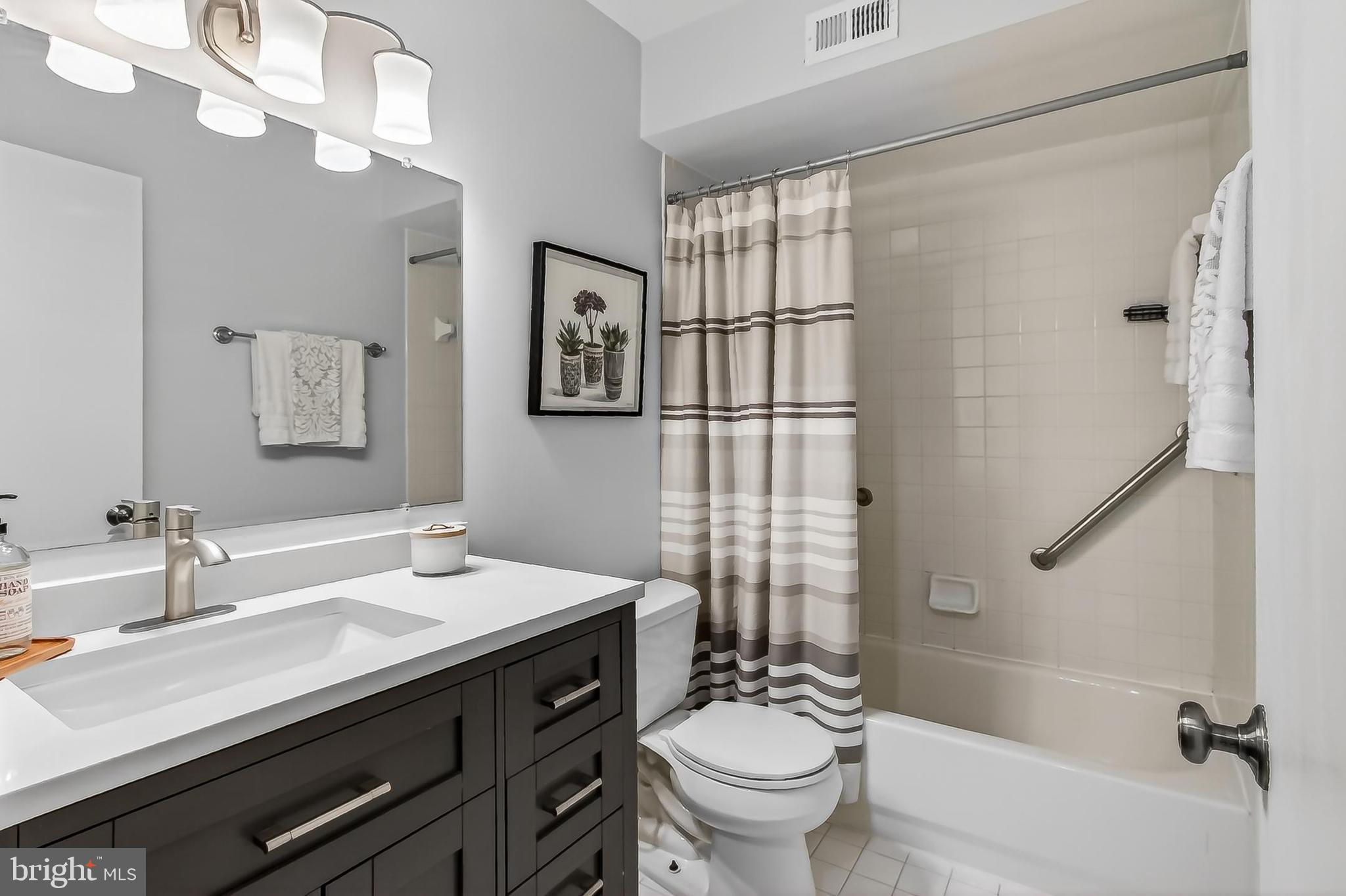 5833 Royal Ridge Drive, Unit 943 Springfield, VA 22152 - Photo 28 of 45 a bathroom with a sink a toilet a mirror and shower