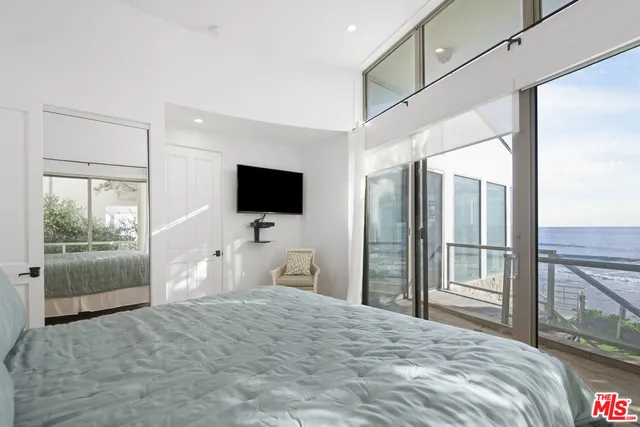 a bedroom with a bed tv and a window