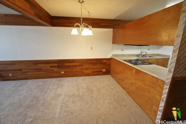 a view of a kitchen with a sink and chandelier
