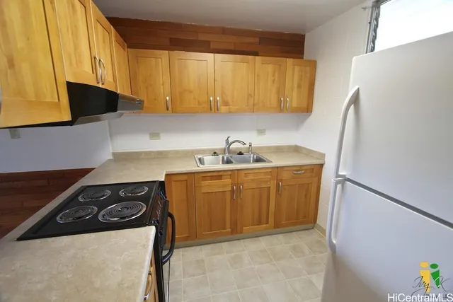 a kitchen with a sink a stove and a refrigerator