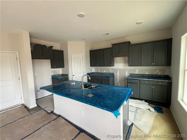 a kitchen with a sink a microwave and cabinets