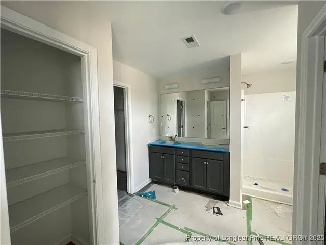 a spacious bathroom with a mirror and a sink