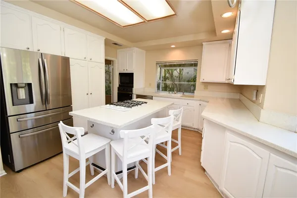 a kitchen with stainless steel appliances a refrigerator sink and cabinets