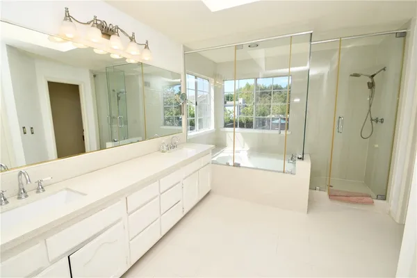 a spacious bathroom with a tub shower and sink