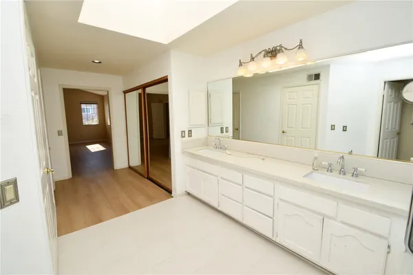 a spacious bathroom with a granite countertop sink and a mirror