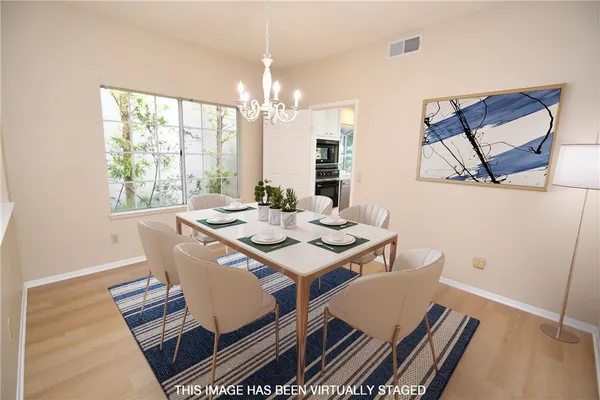 a view of a dining room with furniture a chandelier and wooden floor