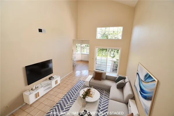 a living room with furniture a flat screen tv and a window