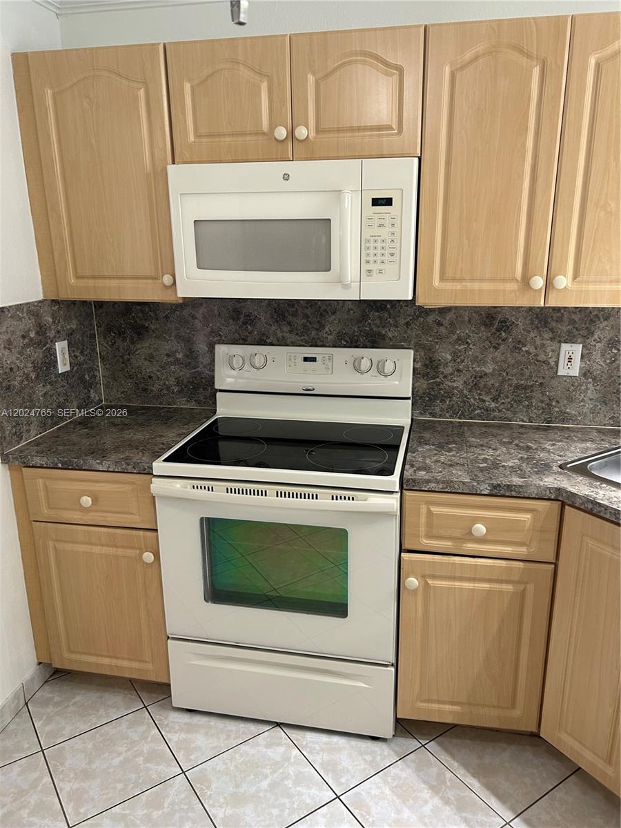 10919 West Okeechobee Road, Unit 101 Hialeah Gardens, FL 33018 - Photo 12 of 21 a stove top oven sitting inside of a kitchen