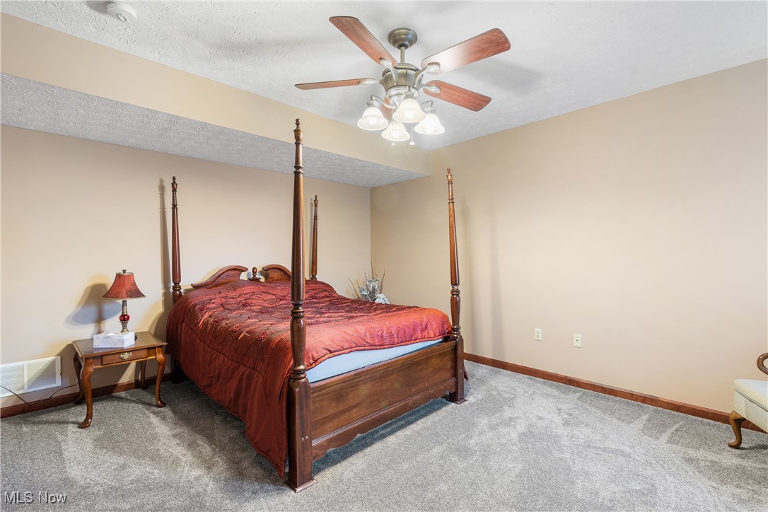 3393 Friendsville Road Wooster, OH 44691 - Photo 27 of 34 Bedroom with a textured ceiling, carpet flooring, visible vents, a ceiling fan, and baseboards