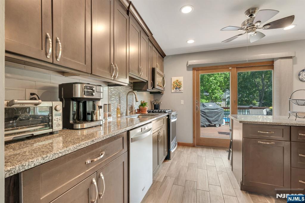 55 Marcia Road Ringwood, NJ 07456 - Photo 8 of 42 a kitchen with stainless steel appliances granite countertop a refrigerator a sink dishwasher a stove and a sink with wooden floor