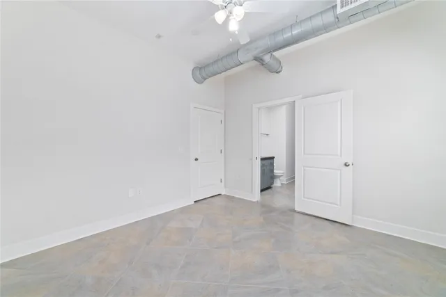 a bathroom with a granite countertop toilet sink and mirror