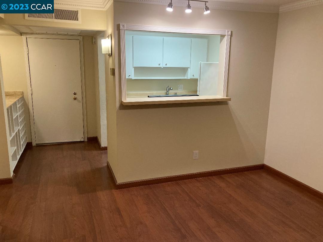 an empty room with wooden floor and cabinet