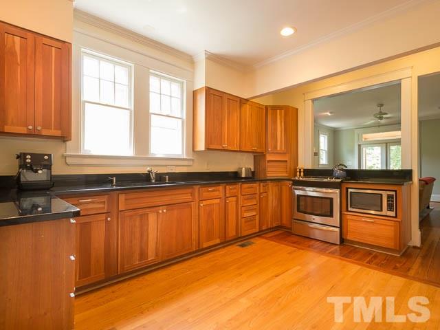 115 Hudson Street Raleigh, NC 27608 - Photo 10 of 25 a kitchen with granite countertop a stove a sink and a refrigerator