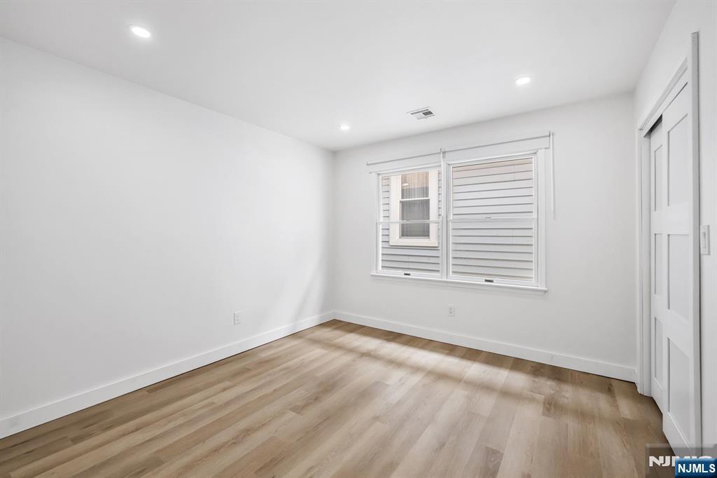 123 Chestnut Street Garfield, NJ 07026 - Photo 7 of 27 an empty room with wooden floor and windows
