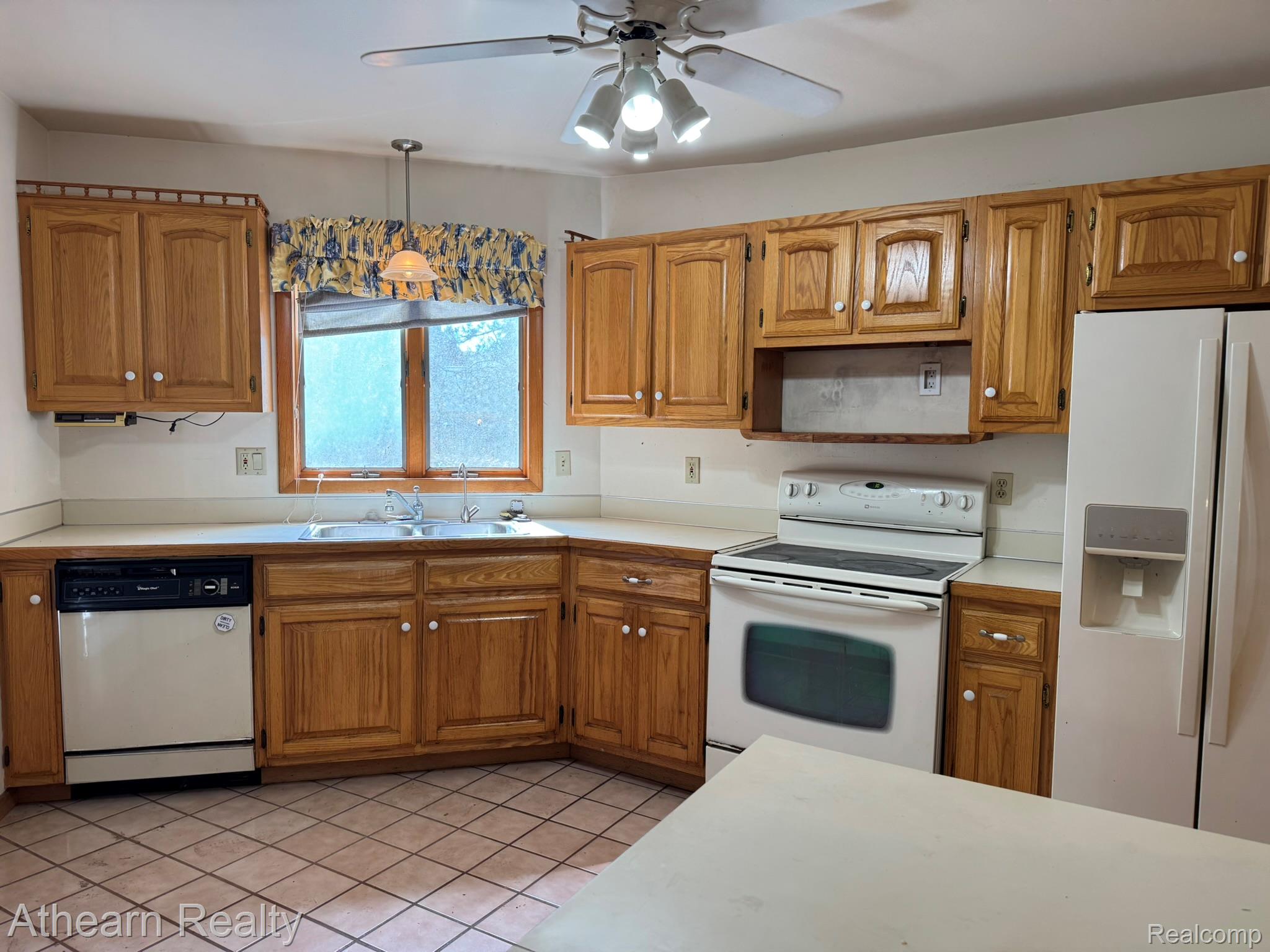 11449 Torrey Road Fenton, MI 48430 - Photo 13 of 30 Wood-finish cabinetry, tile flooring, integrated double basin sink, ceiling fan with light kit, and white appliances