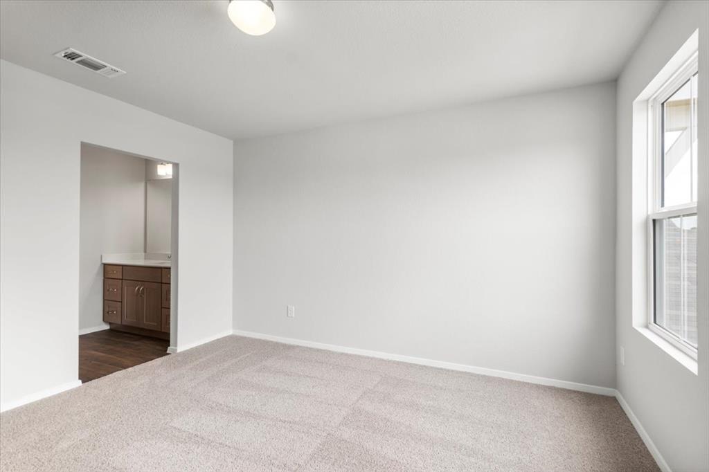 2707 Totley Road Manor, TX 78653 - Photo 25 of 39 Unfurnished bedroom with dark colored carpet and ensuite bathroom