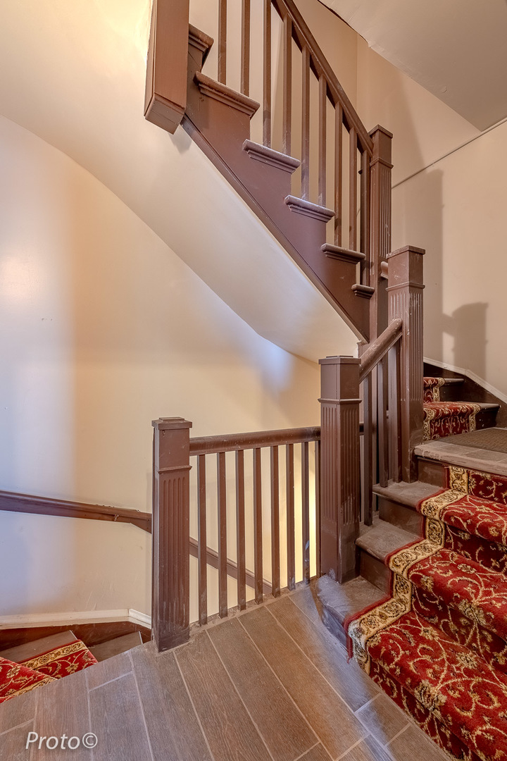 3605 West Cermak Road Chicago, IL 60623 - Photo 18 of 41 a view of staircase with lots of frames on wall and a window