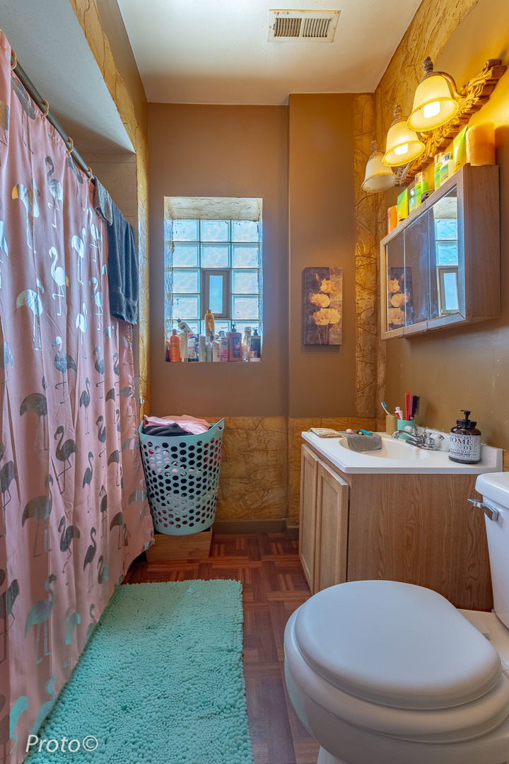 3605 West Cermak Road Chicago, IL 60623 - Photo 29 of 41 a bathroom with a toilet a sink and a window