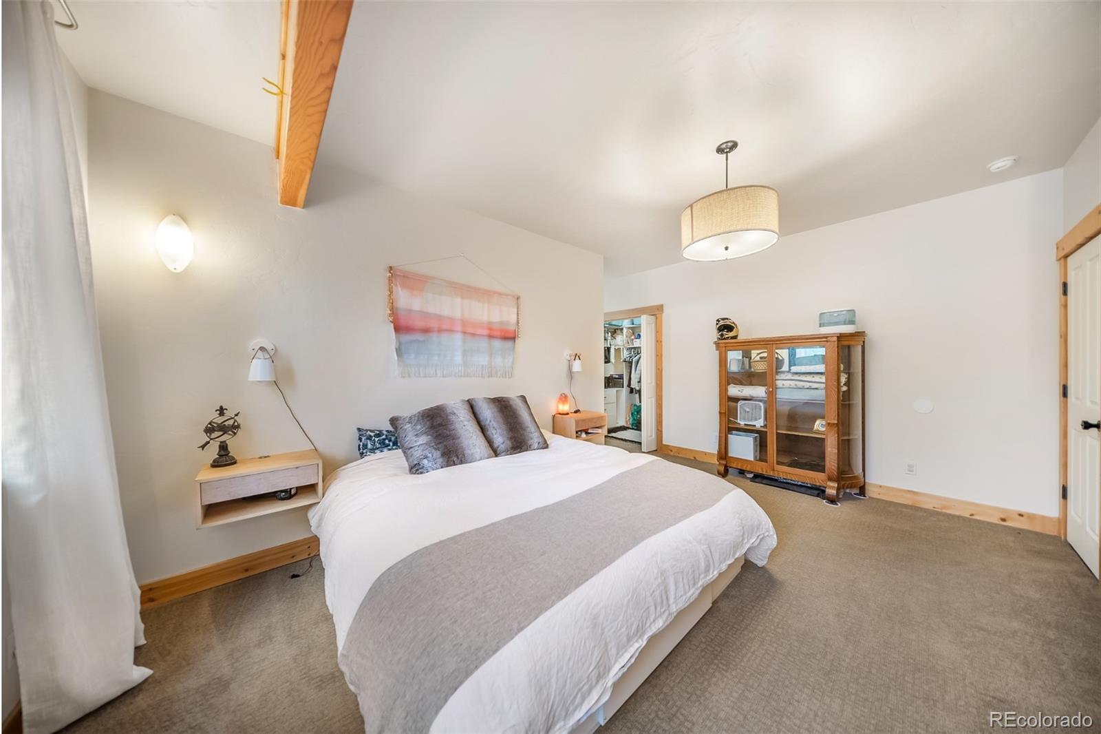 143 East Grand Avenue Hot Sulphur Springs, CO 80451 - Photo 11 of 37 a bedroom with a bed and a chandelier